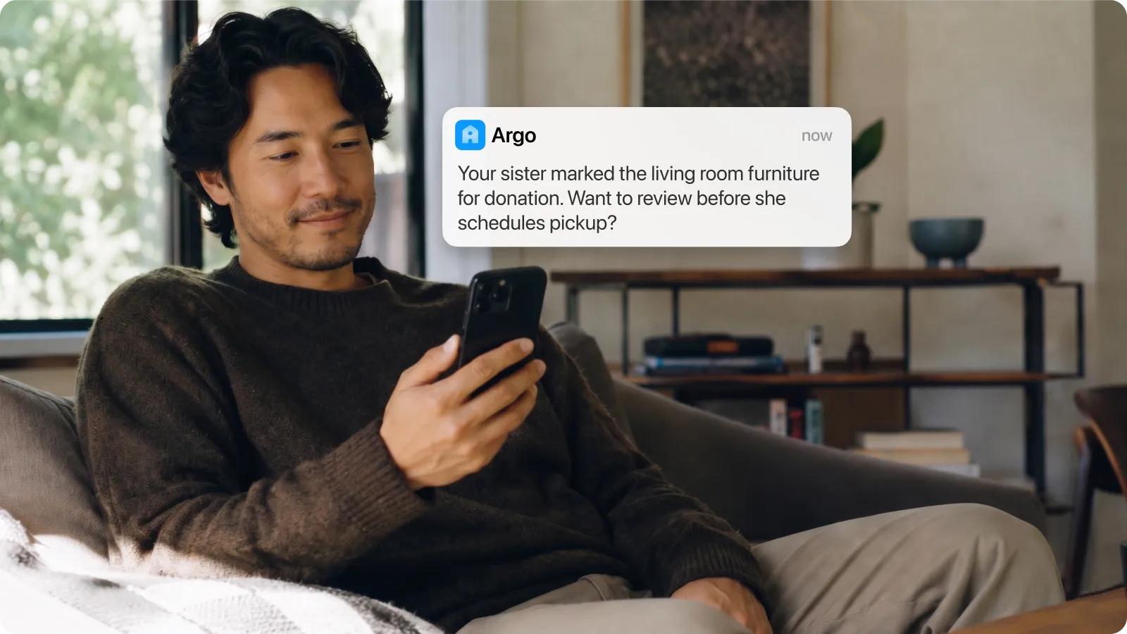 Person on couch reviewing an Argo notification about a family-shared decision